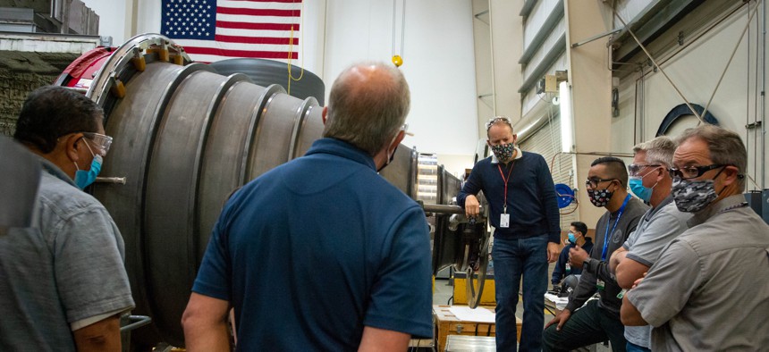 Aeroject Rocketdyne engineers and machinists inspect an engine nozzle. Aeroject Rocketdyne is building the engines for NASAs Space Launch System rocket, which will be used in the Moon mission.