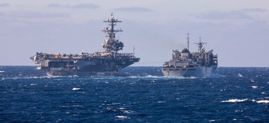 The Nimitz-class aircraft carrier USS George H.W. Bush sails alongside the fast combat support ship USNS Arctic during a replenishment-at-sea, Dec. 19, 2022. 