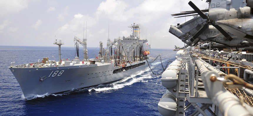 A Military Sealift Command vessel replenishes an amphibious assault ship.