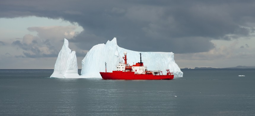 The research vessel Nathaniel B. Palmer cruises by an iceberg near Antarctica.