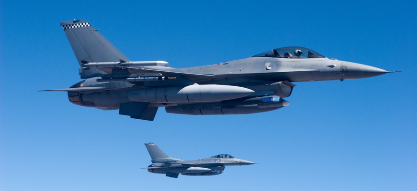 A pair of F-16 fighter jets fly in formation.