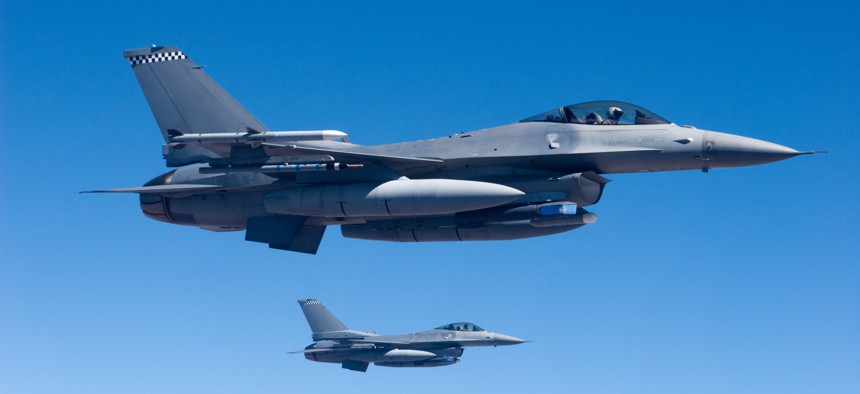 A pair of F-16 fighter jets fly in formation.