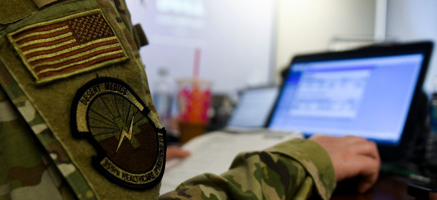 U. S. Air Force Capt. Kristina Linden, 355th Mental Health Clinic Social Worker, works on a task during Military Health System Genesis training at Davis-Monthan Air Force Base, Arizona, April 7, 2021. DOD is planning a sole source extension to migrate that system to the cloud before launching a sustainment contract.