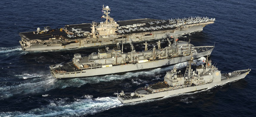 The aircraft carrier USS John C. Stennis (back), and the guided-missile cruiser USS Mobile Bay (front), steam alongside the fast combat support ship USNS Bridge during a replenishment-at-sea.