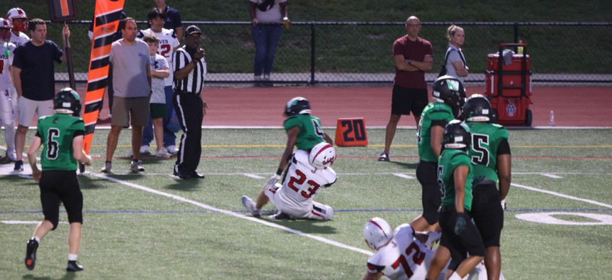 Justice Wolves linebacker James Wakeman (#23) makes a tackle behind the line of scrimmage in a game against Wakefield High School.