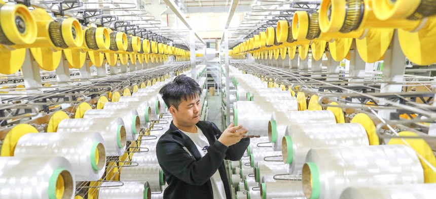 A worker producing bulletproof protective composite materials in Huzhou, China, on May 13, 2024. 