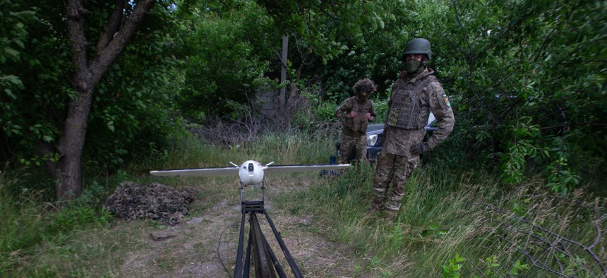 A view of two Ukrainian soldiers with a VB140 interceptor drone on a catapult launcher near the frontline on the outskirts of the city of Sumy, northeastern Ukraine, on June 13, 2026.