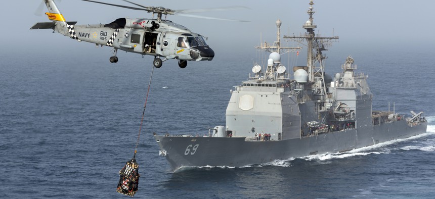 A Navy helicopter services the USS Vicksburg.