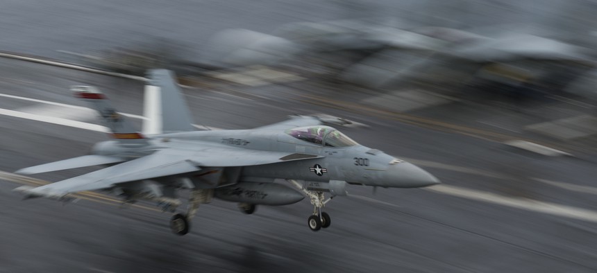 An EA-18G Growler landing on the deck of the USS George H.W. Bush aircraft carrier.